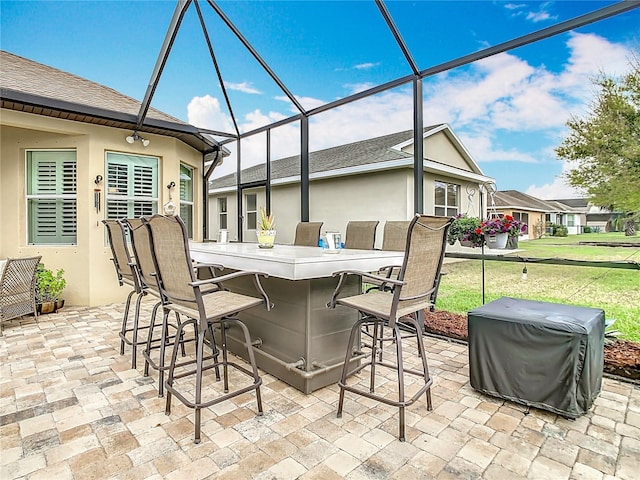 view of patio with outdoor dry bar and a lanai