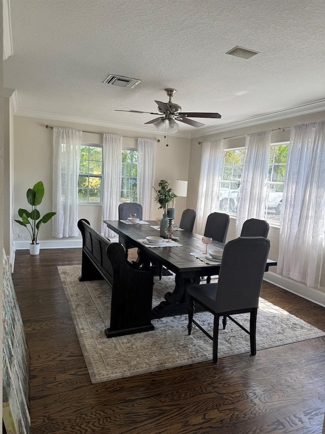 dining room with visible vents, dark wood-type flooring, a ceiling fan, a textured ceiling, and crown molding