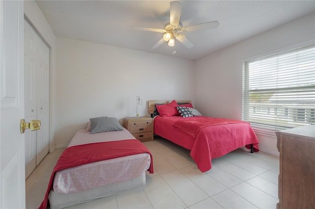 bedroom with a closet, a ceiling fan, and light tile patterned flooring