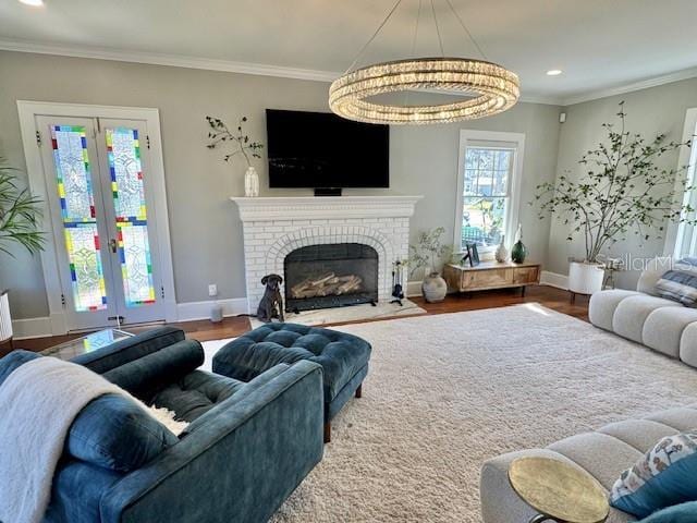 living area with crown molding, a fireplace, wood finished floors, and french doors