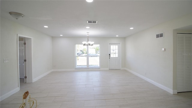 spare room with a notable chandelier, baseboards, visible vents, and recessed lighting