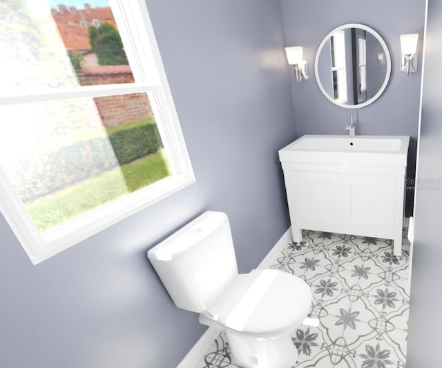 half bathroom with baseboards, vanity, and toilet