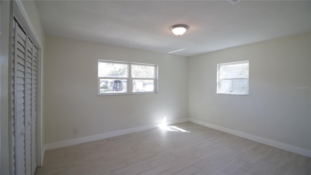 empty room featuring light wood-style floors and baseboards