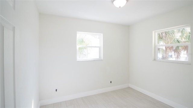 empty room with plenty of natural light and baseboards