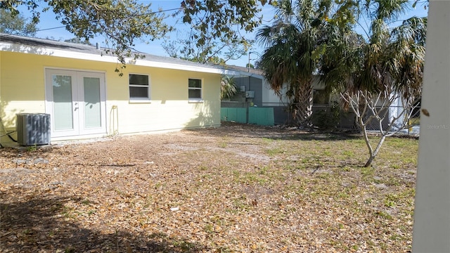 view of yard featuring cooling unit, french doors, and fence