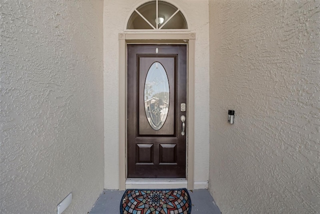 doorway to property featuring stucco siding