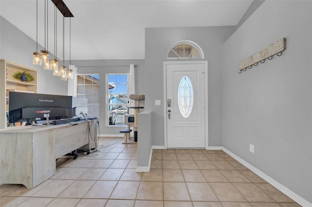 foyer entrance featuring lofted ceiling, baseboards, and light tile patterned floors