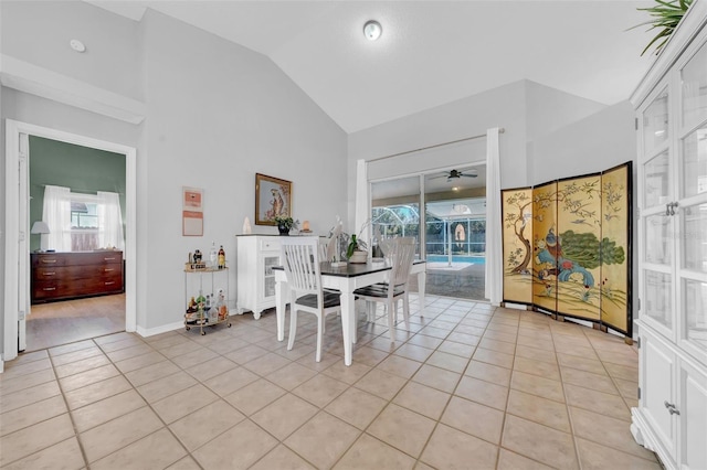 dining area featuring a ceiling fan, light tile patterned flooring, high vaulted ceiling, and baseboards