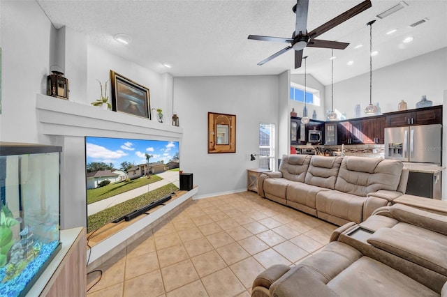 living area with visible vents, a ceiling fan, a textured ceiling, high vaulted ceiling, and light tile patterned flooring