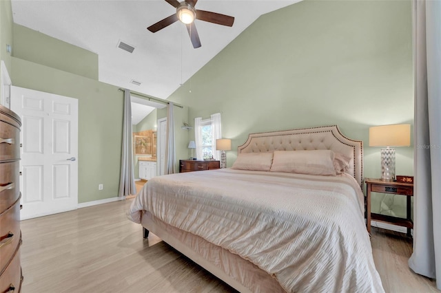 bedroom with light wood finished floors, baseboards, visible vents, and high vaulted ceiling