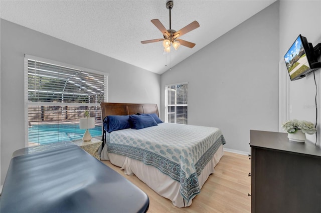 bedroom featuring lofted ceiling, ceiling fan, a textured ceiling, baseboards, and light wood-style floors