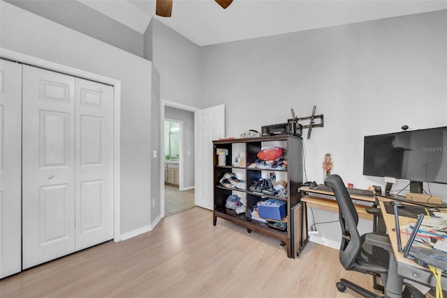 office featuring a ceiling fan, baseboards, and light wood finished floors