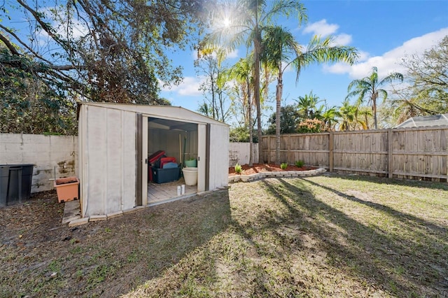 view of yard with a fenced backyard, a storage unit, and an outdoor structure