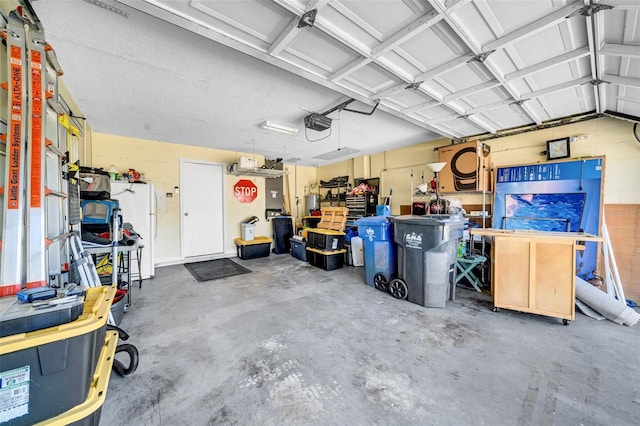 garage featuring freestanding refrigerator and a garage door opener