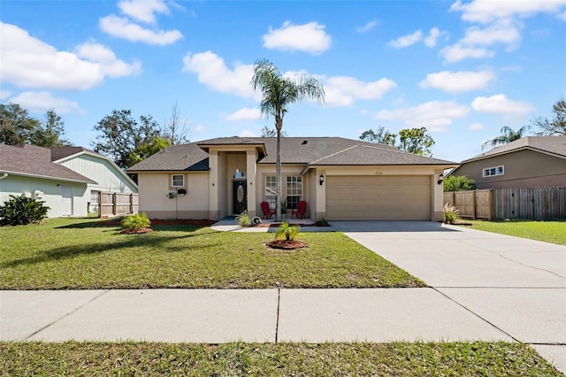 view of front of property featuring stucco siding, fence, a garage, driveway, and a front lawn