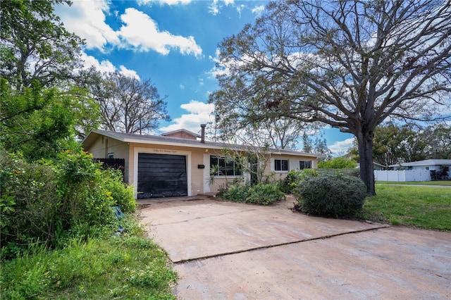 ranch-style house with a garage and concrete driveway