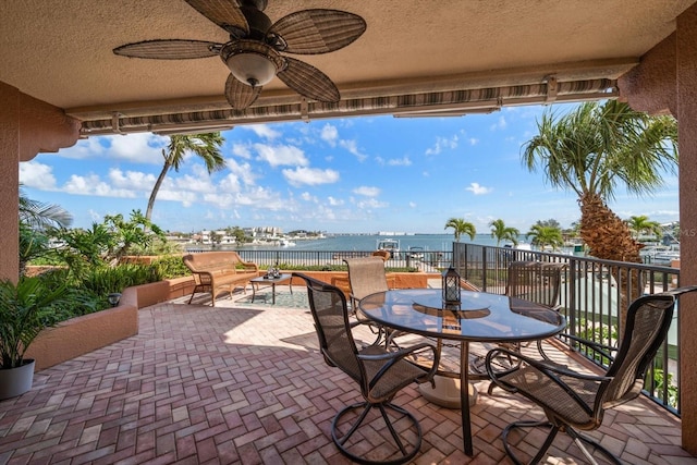 view of patio / terrace featuring a water view, ceiling fan, and outdoor dining space