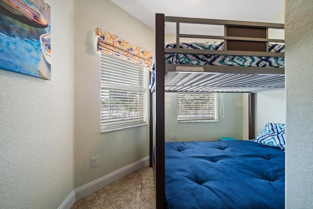 bedroom featuring tile patterned flooring and baseboards