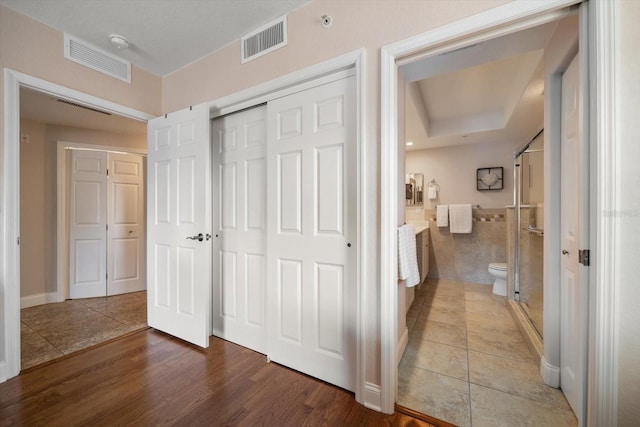 bedroom with a closet, visible vents, and wood finished floors