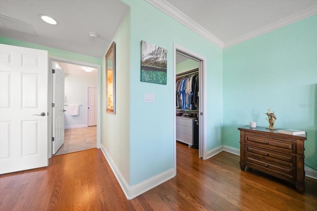 hall featuring crown molding, baseboards, and wood finished floors