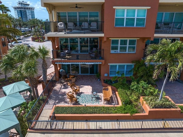 back of house with a patio, a ceiling fan, a balcony, and stucco siding