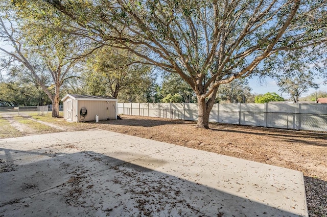 view of yard featuring a storage shed, a fenced backyard, a patio area, and an outdoor structure