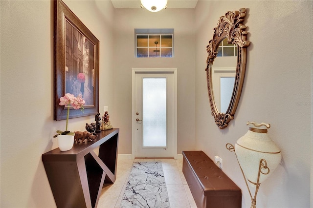 doorway with light tile patterned flooring and baseboards