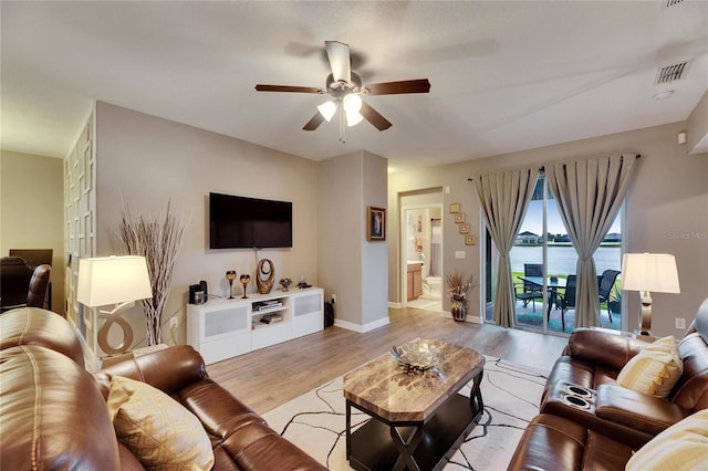 living area with visible vents, ceiling fan, light wood-style flooring, and baseboards