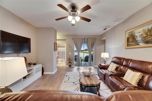 living room with light wood-style floors, ceiling fan, visible vents, and baseboards