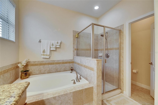 bathroom featuring a garden tub, a shower stall, and tile patterned floors