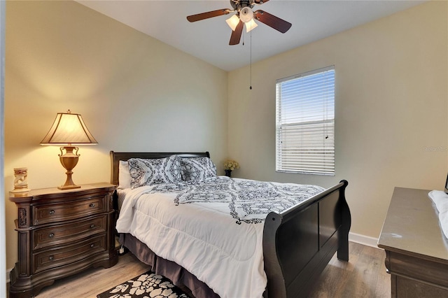 bedroom with ceiling fan, light wood-type flooring, and baseboards