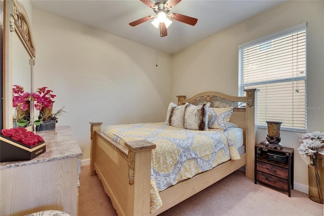 bedroom featuring baseboards, a ceiling fan, and light colored carpet