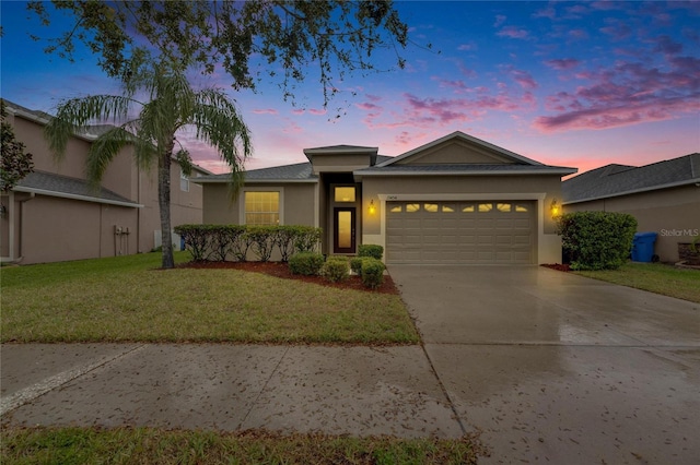 view of front of home with driveway, a garage, a lawn, and stucco siding