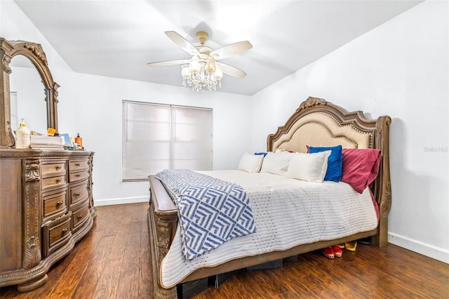 bedroom with ceiling fan, baseboards, and dark wood-type flooring