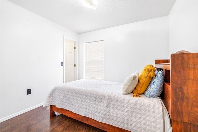 bedroom with baseboards and wood finished floors