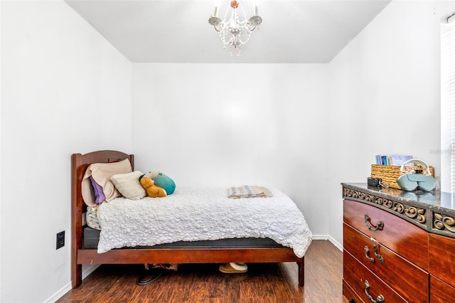 bedroom featuring an inviting chandelier, baseboards, and dark wood-style flooring