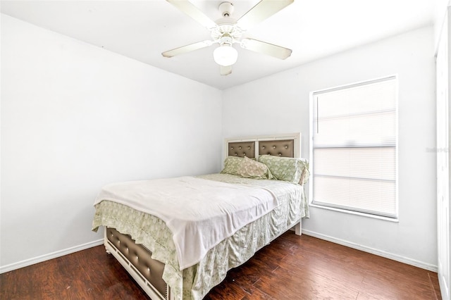 bedroom with dark wood-style floors, ceiling fan, and baseboards