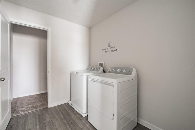 washroom with dark wood-type flooring, laundry area, washer and clothes dryer, and baseboards