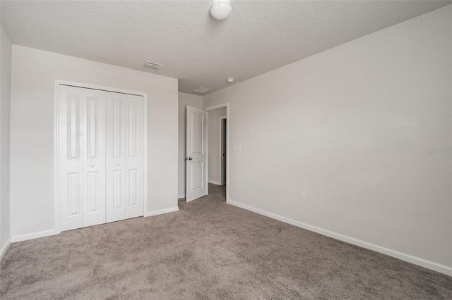 unfurnished bedroom with carpet floors, baseboards, visible vents, and a closet