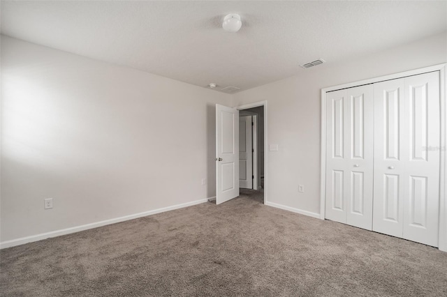 unfurnished bedroom with carpet floors, baseboards, visible vents, and a closet