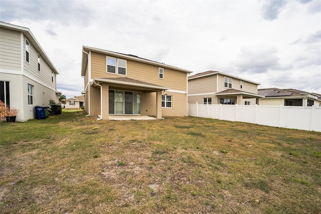 rear view of property with a patio area, a yard, and fence