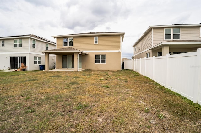 back of property featuring a lawn, a patio area, and a fenced backyard