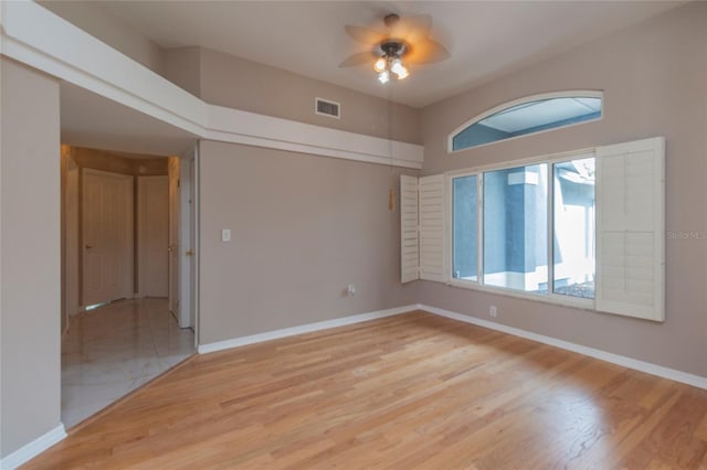 spare room featuring visible vents, baseboards, and light wood-style floors