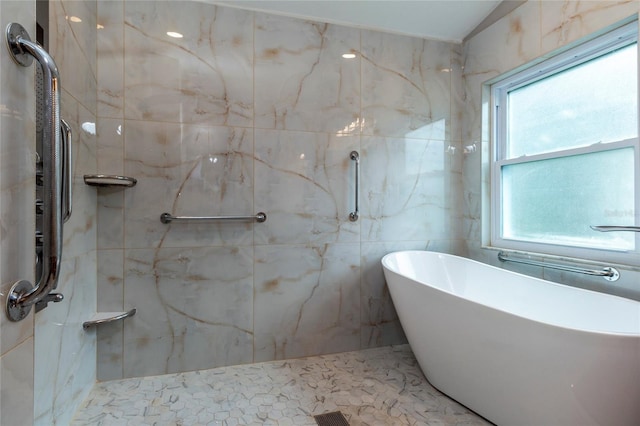 bathroom featuring a freestanding tub, a marble finish shower, and tile walls