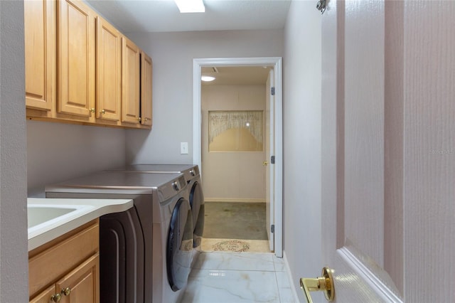 clothes washing area with a sink, cabinet space, light colored carpet, and washing machine and clothes dryer