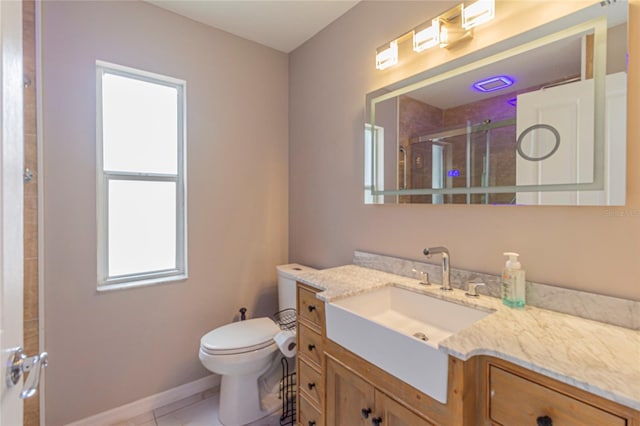 bathroom with tile patterned flooring, a shower stall, baseboards, toilet, and vanity