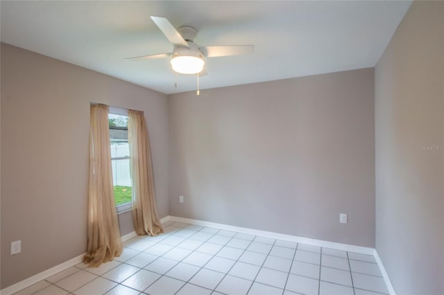 empty room featuring light tile patterned floors, baseboards, and a ceiling fan