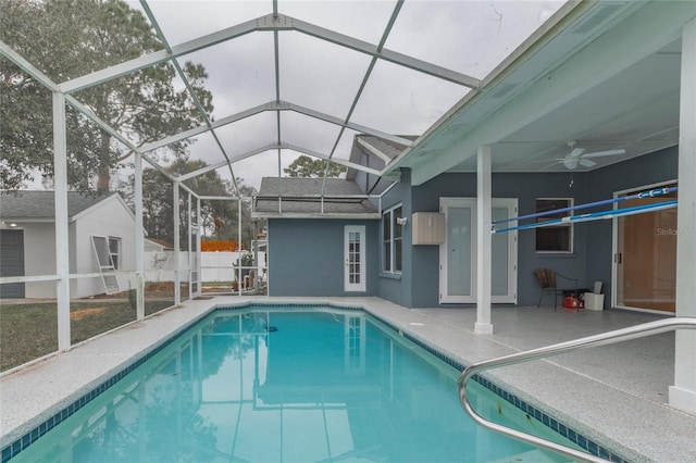 view of pool with glass enclosure, a patio, a ceiling fan, and a fenced in pool