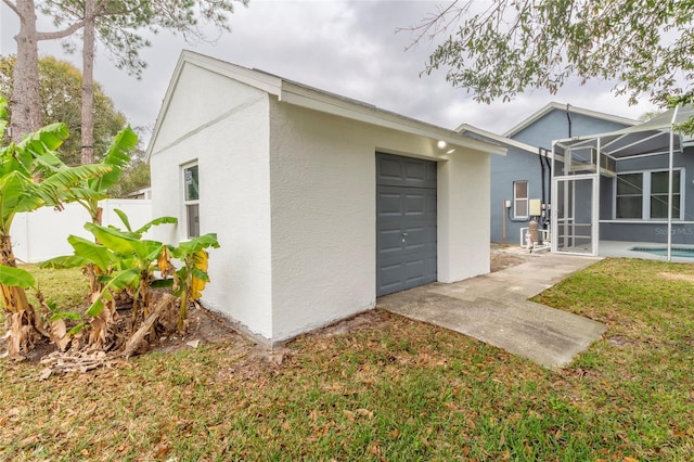 back of property featuring glass enclosure, fence, a garage, and stucco siding