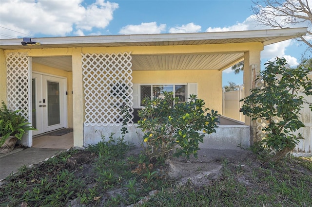 exterior space featuring stucco siding and french doors